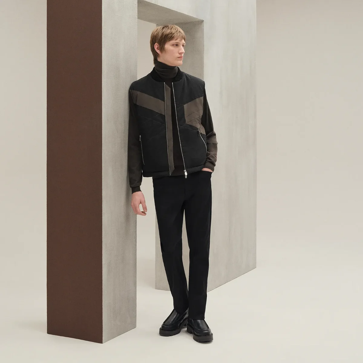 Hermès winter campaign, model in scarf against a studio backdrop.